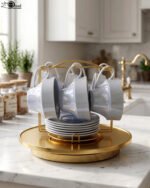 Luxury ceramic tea set with 6 cups, 6 saucers, and a golden stand on a kitchen counter