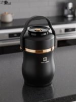 Matte black portable insulated lunch box jar with gold trim accent and black top handle on a kitchen counter