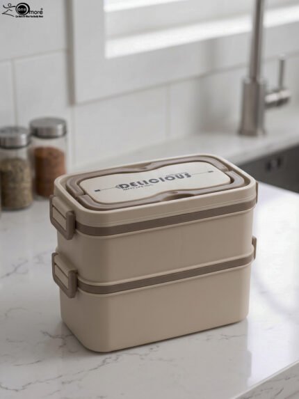 Beige and brown 2 in 1 double layer bento lunch box with locking latches on a kitchen counter