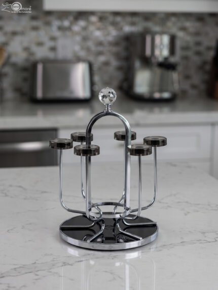 Modern silver chrome glass stand with crystal top finial holding six inverted glasses on a kitchen countertop.