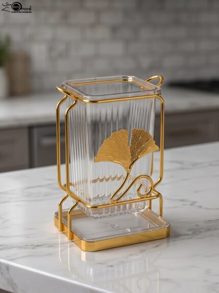 Luxury gold frame spoon stand with fluted clear acrylic container featuring a gold ginkgo leaf emblem on a marble countertop.