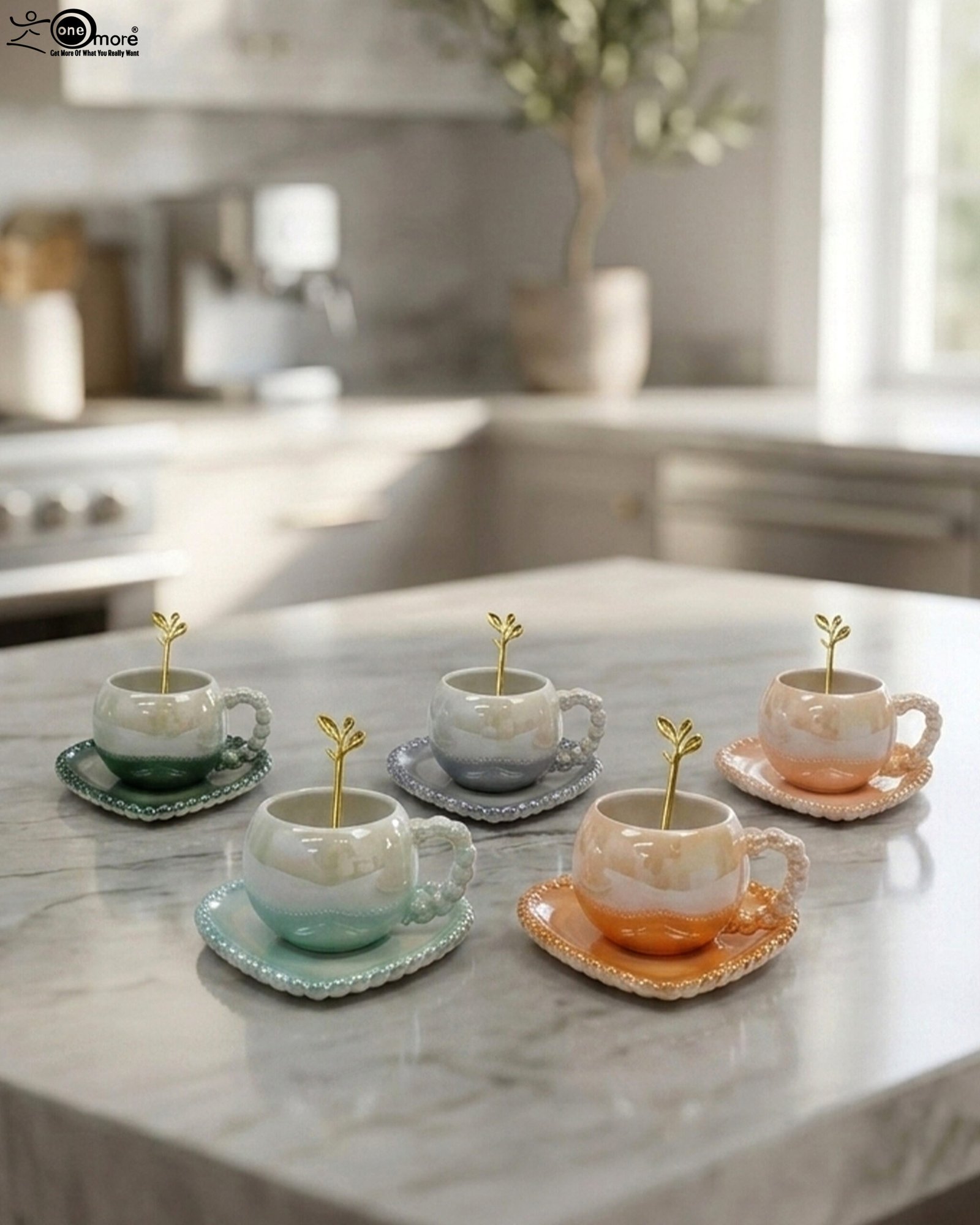 1 Elegant pastel ceramic cup and saucer set with a matching gold spoon and beaded handle on a marble kitchen countertop.