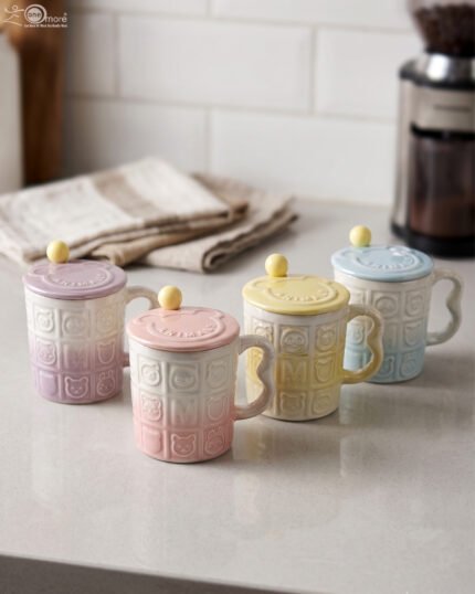 Four pastel ceramic mugs with animal embossed patterns, matching lids with round knobs, and spoons displayed on a kitchen counter