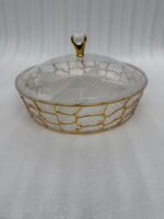 Two transparent crystal dry fruit serving dishes with partitioned interiors, gold geometric patterns, and crystal-topped lids placed on a wooden table.
