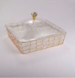 Medium and large luxury clear acrylic dry fruit dishes featuring intricate gold geometric frames and crystal-style knob lids, displayed together on a wooden coffee table in a modern living room.