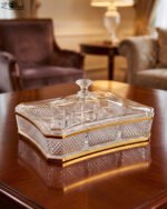 Elegant rectangular crystal dry fruit dish with multiple compartments, gold trim, and a matching lid placed on a wooden table.