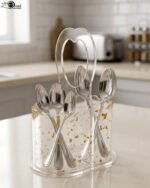 Clear acrylic spoon holder featuring decorative gold flake accents, a convenient top loop carry handle, and organized stainless steel spoons on a kitchen countertop.