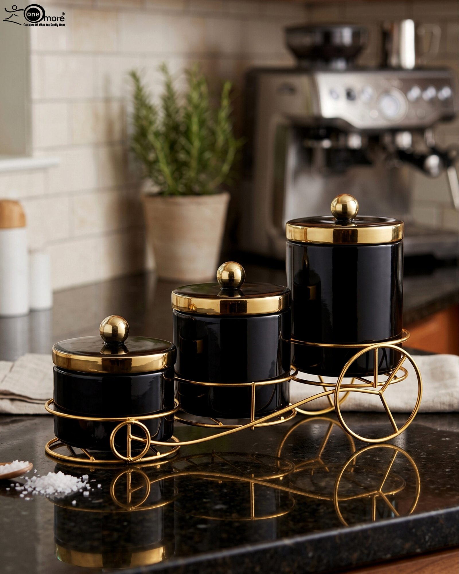 1 Luxury 3-piece black and gold ceramic storage jar set with golden lids arranged on an elegant gold metal cart stand on a modern kitchen countertop.