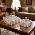 Medium and large luxury clear acrylic dry fruit dishes featuring intricate gold geometric frames and crystal-style knob lids, displayed together on a wooden coffee table in a modern living room.
