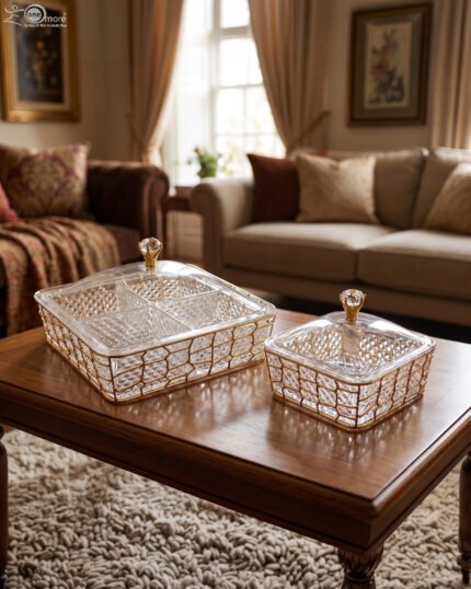 Medium and large luxury clear acrylic dry fruit dishes featuring intricate gold geometric frames and crystal-style knob lids, displayed together on a wooden coffee table in a modern living room.