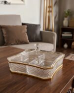 Two square crystal dry fruit dishes with textured patterns and gold trim, displayed in medium and large sizes on a wooden table.