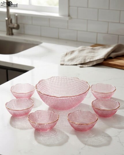 7-piece grey glass fruit set featuring one large serving bowl and six matching small bowls with gold rims, displayed on a kitchen countertop.