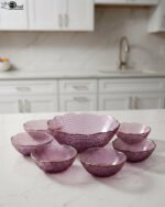 7-piece grey glass fruit set featuring one large serving bowl and six matching small bowls with gold rims, displayed on a kitchen countertop.