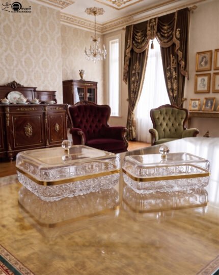 Two elegant crystal dry fruit dishes with gold rims and clear ball-knob lids, displayed in Medium and Large sizes on a table.