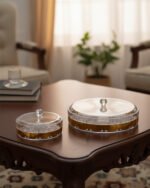 Three luxury crystal dry fruit dishes with gold rims and lids in Small, Medium, and Large sizes displayed on a dark wooden coffee table.