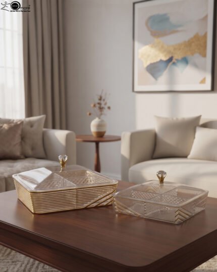 Two luxury clear acrylic dry fruit serving dishes with gold trim, crystal knobs, and partitioned compartments displayed on a modern wooden coffee table.