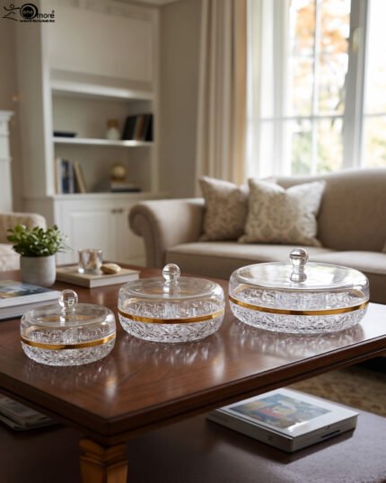 Three elegant cut-crystal dry fruit dishes with gold rims and matching spherical-handle lids displayed in Small, Medium, and Large sizes on a wooden coffee table in a modern living room.