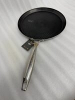 Two black honeycomb non-stick tawas measuring 28cm and 32cm with ergonomic stainless steel handles displayed on a dark slate surface.