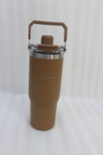 An assortment of colorful 900ml stainless steel tumblers with handles and transparent straw lids arranged neatly on a kitchen counter.