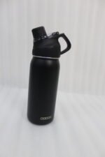 Four Dodge 630mL stainless steel water bottles in black, sage green, grey, and beige lined up on a kitchen counter.
