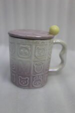 Four pastel ceramic mugs with animal embossed patterns, matching lids with round knobs, and spoons displayed on a kitchen counter