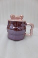 Four pastel ceramic mugs with matching lids and cute bow details, featuring a glossy pearl finish arranged on a marble kitchen countertop.