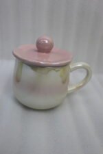 Four colorful pastel ceramic mugs with matching lids featuring sphere knobs, arranged neatly on a marble kitchen countertop with cinematic lighting