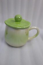 Four colorful pastel ceramic mugs with matching lids featuring sphere knobs, arranged neatly on a marble kitchen countertop with cinematic lighting