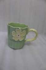 Four pastel ceramic coffee mugs with 3D floral designs lined up on a kitchen counter with cinematic lighting.
