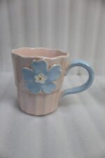 Four pastel ceramic coffee mugs with 3D floral designs lined up on a kitchen counter with cinematic lighting.