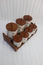 Floral ceramic kitchen canister and jar set with wooden lids and display stand on a kitchen counter