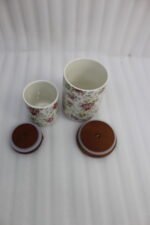 Floral ceramic kitchen canister and jar set with wooden lids and display stand on a kitchen counter