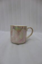 A set of 6 iridescent ceramic tea and coffee mugs hanging on a gold-tone metal stand resting on a wooden tray with a kitchen interior background.