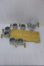 A stylish ceramic tea set in grey and white with wooden-style handles, consisting of six cups and one kettle, neatly arranged on a wooden tray display.