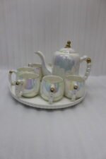 Luxury iridescent ceramic tea set with 6 cups, 1 kettle, and a rotating tray displayed on a marble kitchen counter