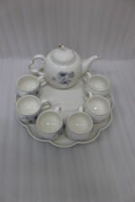 Elegant ceramic tea set featuring 6 floral-patterned cups, 1 kettle, and a wooden rotating tray on a modern kitchen countertop.