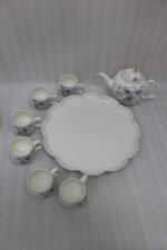Elegant ceramic tea set featuring 6 floral-patterned cups, 1 kettle, and a wooden rotating tray on a modern kitchen countertop.