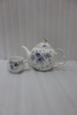Elegant ceramic tea set featuring 6 floral-patterned cups, 1 kettle, and a wooden rotating tray on a modern kitchen countertop.