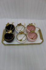 Luxury ceramic ice cream set with six multi-colored bowls and a gold-trimmed serving tray on a white marble kitchen counter