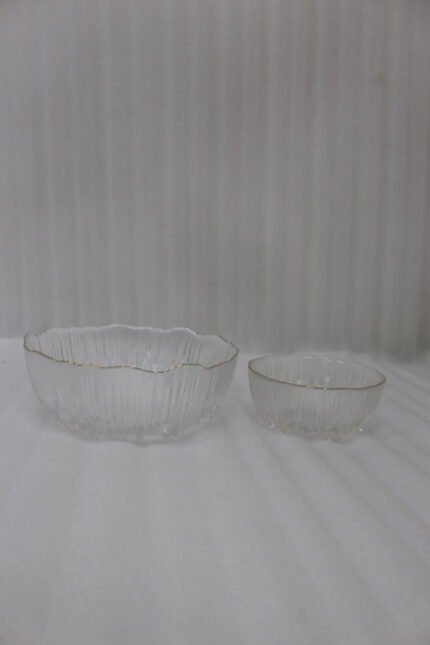 7-piece grey ribbed glass fruit set featuring one large serving bowl and six small bowls with elegant gold rims, displayed on a kitchen counter.