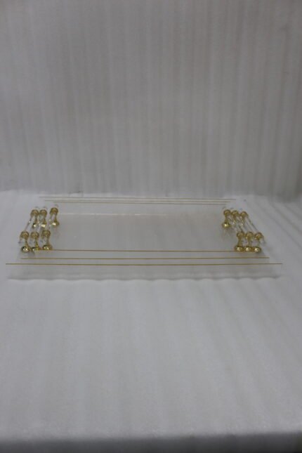 Clear acrylic tray set with textured glass look, gold accents, and transparent handles displayed on a white marble countertop.