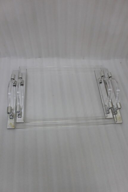 Clear acrylic serving tray set with polished handles displayed on a marble countertop in a modern kitchen setting