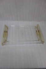 Nesting clear acrylic serving tray set with polished gold handles displayed on a white marble kitchen countertop.