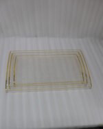 Nesting clear acrylic serving tray set with elegant gold trim and built-in handles, displayed on a modern kitchen countertop.