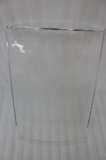 Set of clear acrylic serving trays with built-in handles and textured bases displayed on a marble kitchen counter next to an espresso machine and ceramic cups.