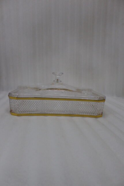 Elegant rectangular crystal dry fruit dish with multiple compartments, gold trim, and a matching lid placed on a wooden table.