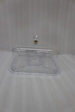 Clear acrylic compartmentalized dry fruit and cake serving dish with a square transparent lid and crystal handle on a wooden table.