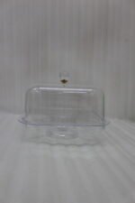 Clear acrylic compartmentalized dry fruit and cake serving dish with a square transparent lid and crystal handle on a wooden table.