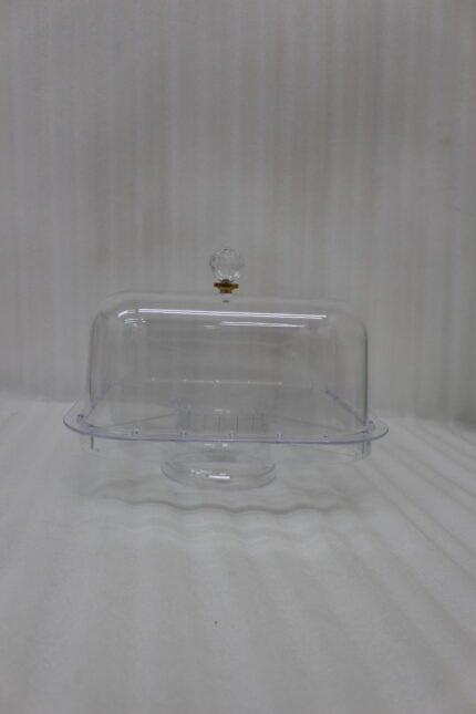 Clear acrylic compartmentalized dry fruit and cake serving dish with a square transparent lid and crystal handle on a wooden table.