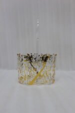 Clear acrylic spoon holder and cutlery caddy with gold accent patterns and a heart-shaped handle on a kitchen countertop holding utensils.
